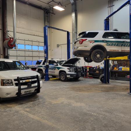 Photograph of Fleet Management Garage Bay with cars being worked on.