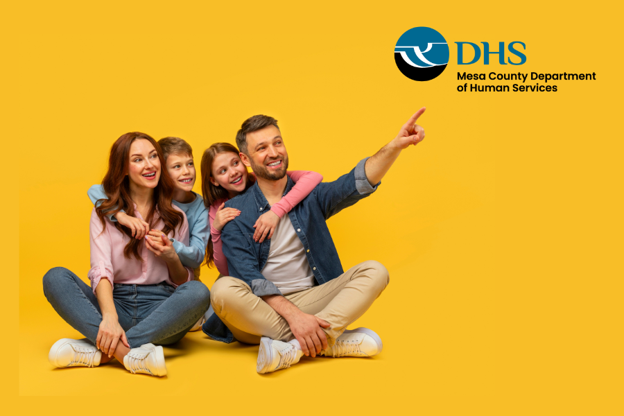 Family pointing at MCDHS logo with a yellow background.